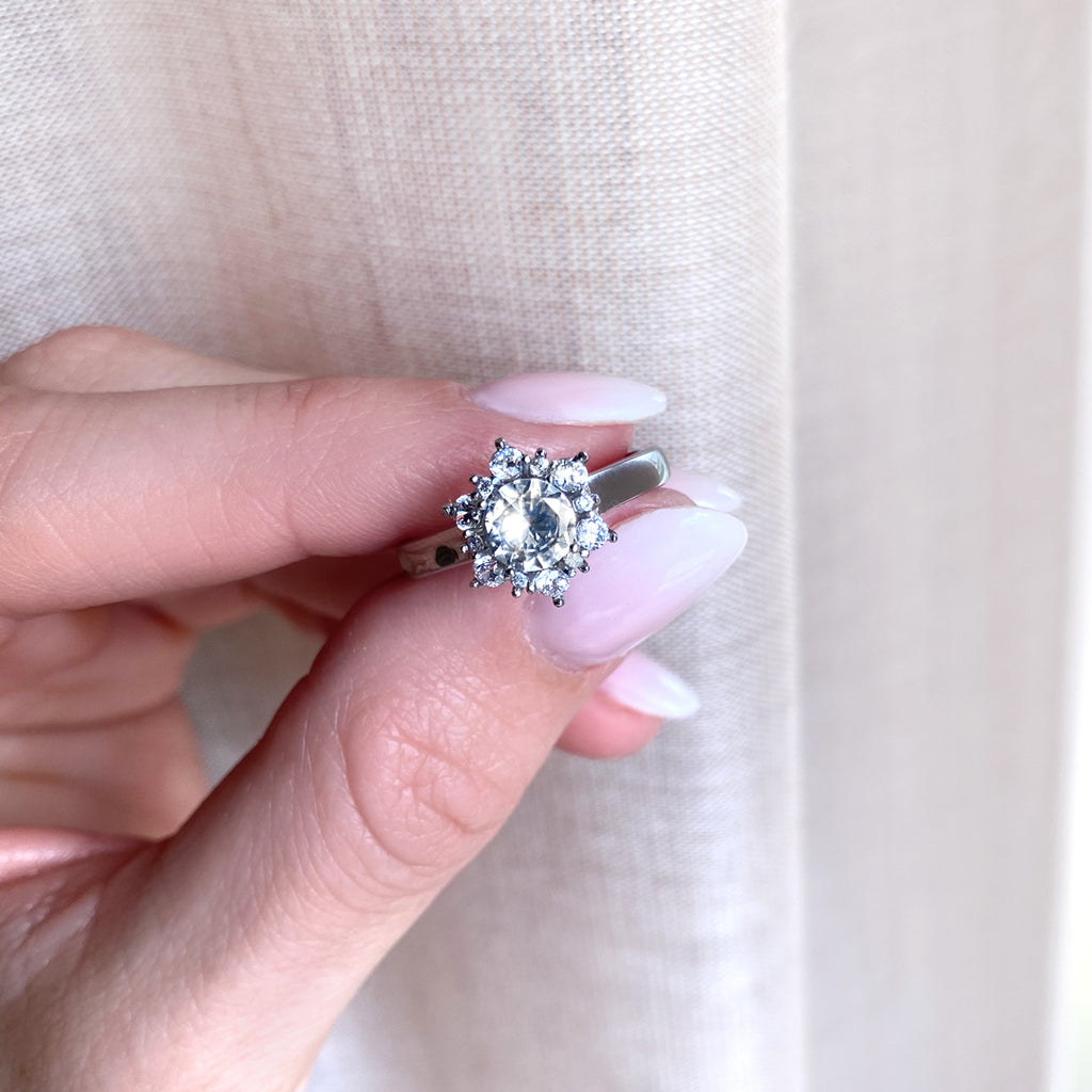 Vacker Exklusiv ring med stenar formade som en Star Halo runt mittenstenen