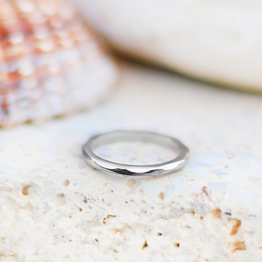 Smal ring i stål med fasade kanter som ger ringen en fin struktur.