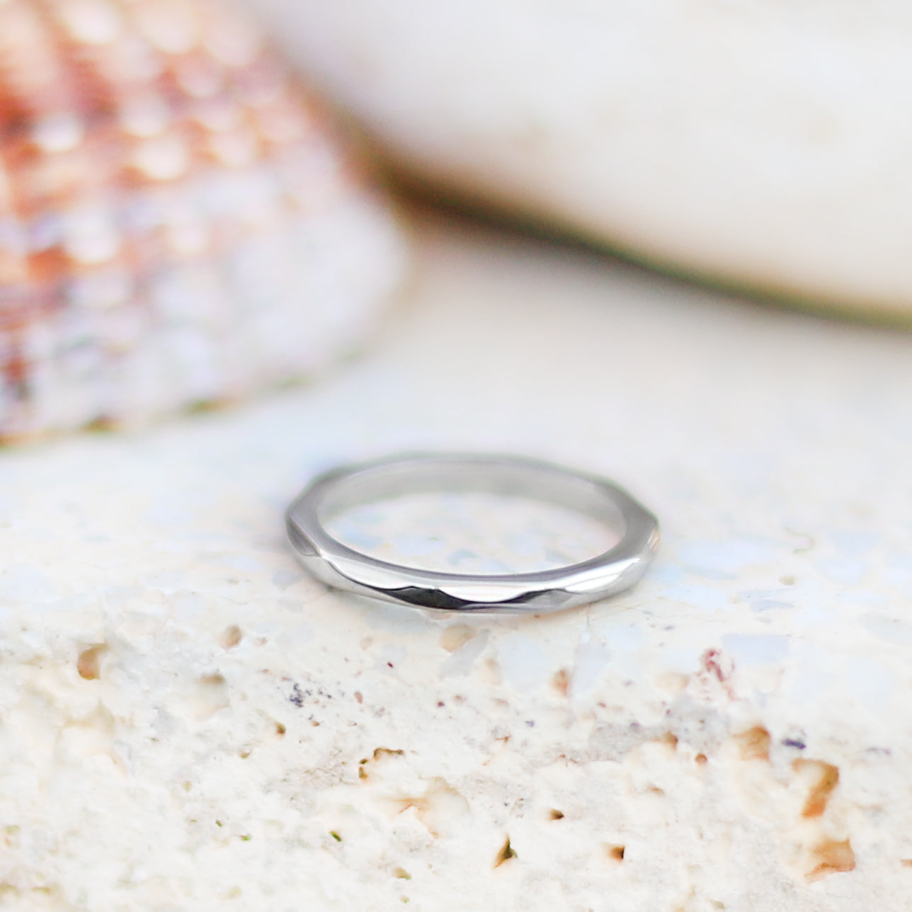 Smal ring i stål med fasade kanter som ger ringen en fin struktur.