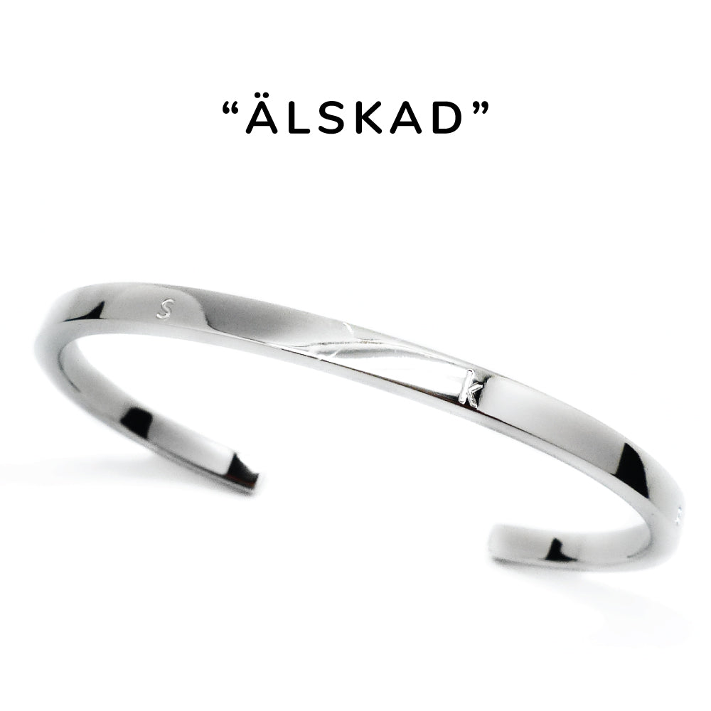 Smalt stilrent armband i blank stål med text graverat på ovansidan