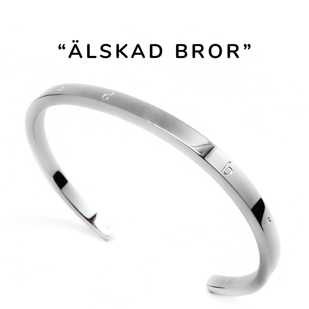 Smalt stilrent armband i blank stål med text graverat på ovansidan